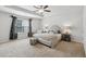 Spacious bedroom with a tray ceiling, ceiling fan, neutral color palette, and lots of natural light at 4173 Chatham Ridge Dr, Buford, GA 30518