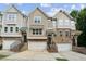 Charming townhomes featuring a brick facade, individual garages, and inviting front entrances at 4173 Chatham Ridge Dr, Buford, GA 30518