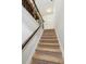 Carpeted staircase featuring dark wood handrails and bright white walls leading to upper floors at 4173 Chatham Ridge Dr, Buford, GA 30518