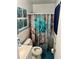 Bathroom with a floral shower curtain, turquoise floors, and matching wall art at 6540 Old White Mill Road Rd, Fairburn, GA 30213