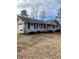 Well-maintained home with gray siding, black shutters, an attached garage, and mature trees in the background at 6540 Old White Mill Road Rd, Fairburn, GA 30213