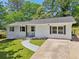 Exterior view of charming home featuring a painted brick facade, well-maintained lawn, and a concrete driveway at 2105 Royal Fox Way, Decatur, GA 30032