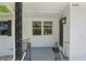 Close up of the front porch featuring decorative metal columns, a white painted brick wall, and a black front door at 2105 Royal Fox Way, Decatur, GA 30032