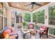 Relaxing screened-in porch with comfortable seating, ceiling fan, and wooded views at 238 Trecastle Sq, Canton, GA 30114