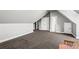 Spacious carpeted bonus room including doors to storage and access to the home at 4251 Lantern Hill Dr, Dacula, GA 30019