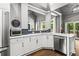 Bright kitchen features stainless steel appliances, white cabinets, and hardwood floors at 4251 Lantern Hill Dr, Dacula, GA 30019