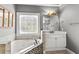 Close up of bathroom tub, vanity and stained glass window at 4251 Lantern Hill Dr, Dacula, GA 30019