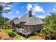 Beautiful rear exterior featuring a large deck, well-maintained lawn, and mature trees at 4251 Lantern Hill Dr, Dacula, GA 30019