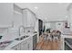 Bright kitchen features white cabinets, stainless steel appliances, and a dining area with hardwood floors at 786 Neal Nw St, Atlanta, GA 30318