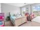 Well-lit bedroom featuring bright walls, playful decor, and two windows for natural light at 9307 Glenleigh Way, Jonesboro, GA 30236