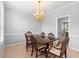 Traditional dining room featuring a chandelier and a wooden dining table set with six chairs at 9307 Glenleigh Way, Jonesboro, GA 30236