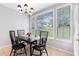 A view of the dining room featuring large windows and a black dining table set with chairs at 9307 Glenleigh Way, Jonesboro, GA 30236