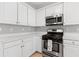 Well-lit kitchen boasting white cabinets and modern stainless steel appliances at 9307 Glenleigh Way, Jonesboro, GA 30236
