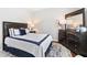 Well-lit main bedroom with a large bed, dresser, and a matching rug at 9307 Glenleigh Way, Jonesboro, GA 30236