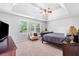 Spacious main bedroom with neutral carpet, ceiling fan, and windows for natural light at 9307 Glenleigh Way, Jonesboro, GA 30236
