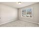 Cozy bedroom with carpet flooring and a window providing natural light and neighborhood view at 181 Dewy Rd # 70, Lilburn, GA 30047