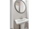 Elegant powder room featuring a pedestal sink, round mirror, and stylish fixtures at 181 Dewy Rd # 70, Lilburn, GA 30047