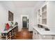 Hallway with unique wine storage, white-painted wood walls, and views to the entryway at 2 N Broad St, Porterdale, GA 30070