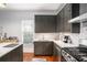 View of the kitchen featuring dark cabinets, stainless steel appliances, and a white countertop island at 2 N Broad St, Porterdale, GA 30070