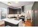 View of the kitchen featuring dark cabinets, stainless steel appliances, and a white countertop island at 2 N Broad St, Porterdale, GA 30070