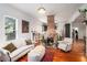 Bright living room showcasing a brick fireplace, hardwood floors, and ample seating space at 2 N Broad St, Porterdale, GA 30070
