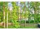 View of the backyard with mature trees and access to the neighborhood pond at 2366 Battle Forest Sw Dr, Marietta, GA 30064