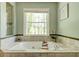 Bathroom with relaxing soaking tub, window view, and tile surround at 2366 Battle Forest Sw Dr, Marietta, GA 30064