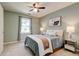 Cozy bedroom with a queen-sized bed, ceiling fan, neutral carpet, and natural light at 2366 Battle Forest Sw Dr, Marietta, GA 30064