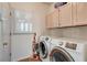 Laundry room includes washer, dryer, window with shutters, and overhead cabinets at 2366 Battle Forest Sw Dr, Marietta, GA 30064