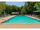 Community pool with lounge chairs, tables, umbrellas, and a pergola at 2366 Battle Forest Sw Dr, Marietta, GA 30064