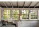 Sunroom with view of backyard trees and lake, gray sofa, mini refrigerator, and built-in storage at 2366 Battle Forest Sw Dr, Marietta, GA 30064