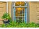 Arched window view of an interior dining area with chandelier and greenery outside at 2366 Battle Forest Sw Dr, Marietta, GA 30064