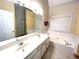 Inviting bathroom featuring a large soaking tub, double sink vanity, and a window for natural light at 6745 Fairfield Trce, Suwanee, GA 30024