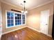Cozy dining area with hardwood floors, a chandelier, and views of the backyard, perfect for casual meals at 6745 Fairfield Trce, Suwanee, GA 30024