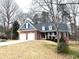 Traditional brick home featuring a two-car garage, welcoming front porch, and well-maintained landscaping at 6745 Fairfield Trce, Suwanee, GA 30024