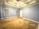 Spacious main bedroom features a trey ceiling, carpet flooring, and two windows for natural light at 6745 Fairfield Trce, Suwanee, GA 30024