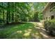 Large backyard, surrounded by dense trees, with a playhouse in the distance at 1690 Trotters Ln, Stone Mountain, GA 30087