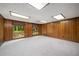 Expansive basement with wood-paneled walls, carpet flooring, and natural light from multiple windows at 1690 Trotters Ln, Stone Mountain, GA 30087