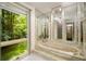 A marble bathroom features a garden tub with a scenic forest view from a large window at 1690 Trotters Ln, Stone Mountain, GA 30087