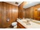 Bathroom features classic wood paneling, vanity, toilet, and tiled floor at 1690 Trotters Ln, Stone Mountain, GA 30087