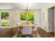 Dining room with dark wood floors, a table set for six, chandelier, and large window overlooking the yard at 1690 Trotters Ln, Stone Mountain, GA 30087