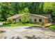 Ranch home featuring horizontal siding, brick accents, a large yard and mature trees at 1690 Trotters Ln, Stone Mountain, GA 30087