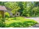 Home with beautiful green front yard featuring an ornamental tree, wooden walkway and mature trees at 1690 Trotters Ln, Stone Mountain, GA 30087