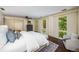 A serene main bedroom with a plush bed, chair, and abundant natural light from the large windows at 1690 Trotters Ln, Stone Mountain, GA 30087