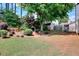 The large grassy backyard includes shrubs and mature trees providing shade and added privacy at 2465 Planters Cove Cir, Lawrenceville, GA 30044