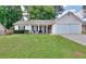 Charming single-story home with a well-manicured lawn, inviting porch, and a two car garage at 2465 Planters Cove Cir, Lawrenceville, GA 30044