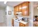 Functional kitchen with wood cabinets, white appliances, and access to the living area at 2465 Planters Cove Cir, Lawrenceville, GA 30044