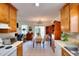 Open kitchen leading into dining area, featuring wood cabinets and updated appliances at 2465 Planters Cove Cir, Lawrenceville, GA 30044