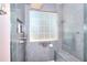 Luxury tiled shower with a built-in seat, frosted window, and recessed shelving at 2465 Planters Cove Cir, Lawrenceville, GA 30044