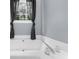 This bathtub is positioned beneath a large window with light-blocking curtains, creating a relaxing and private space at 5640 Rolling Oaks Dr, Cumming, GA 30040